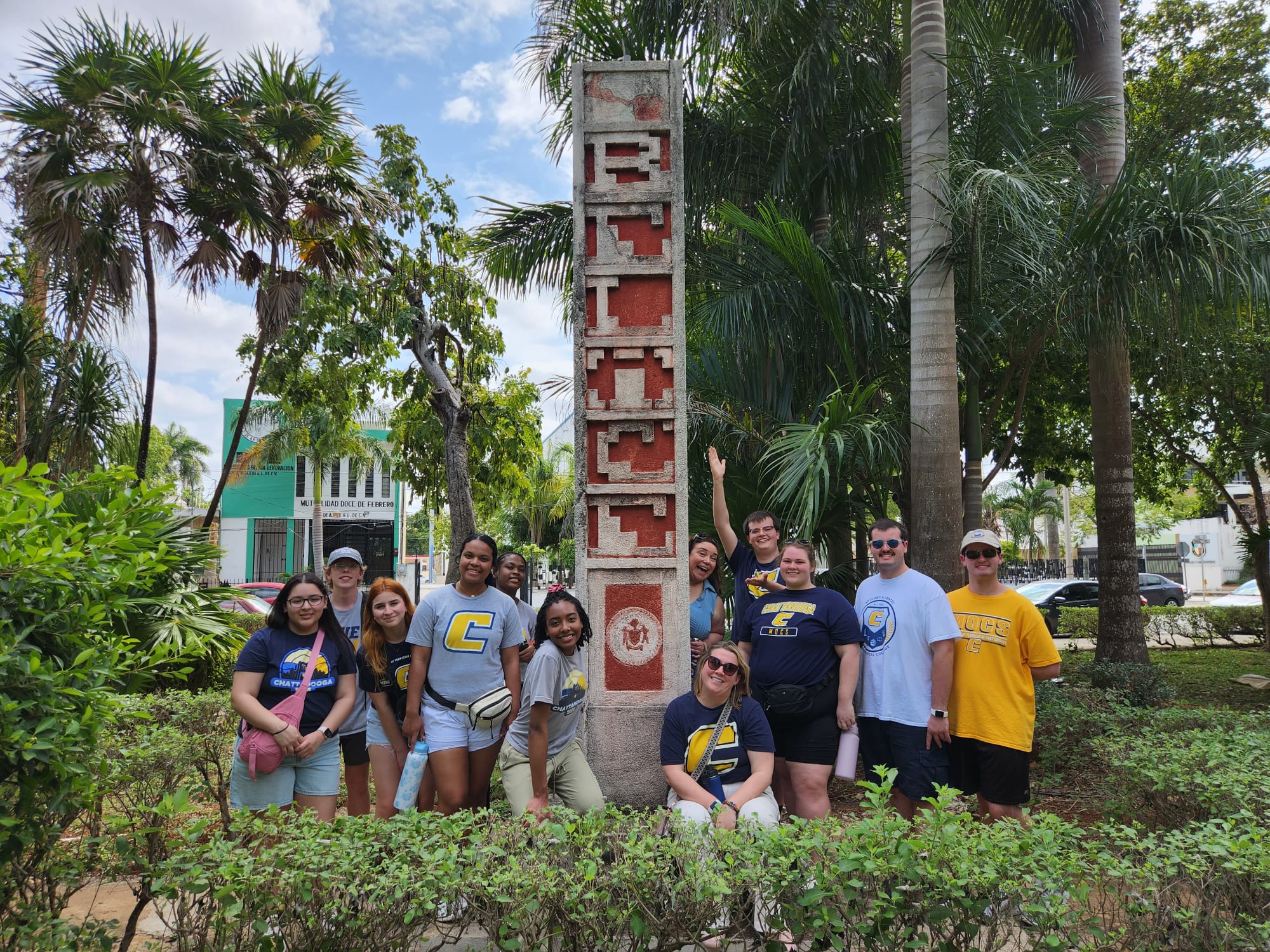 Group of students pose in front of obelisk on study abroad trip in Mexico