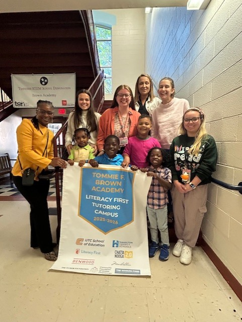 Literacy First group holding a banner with students