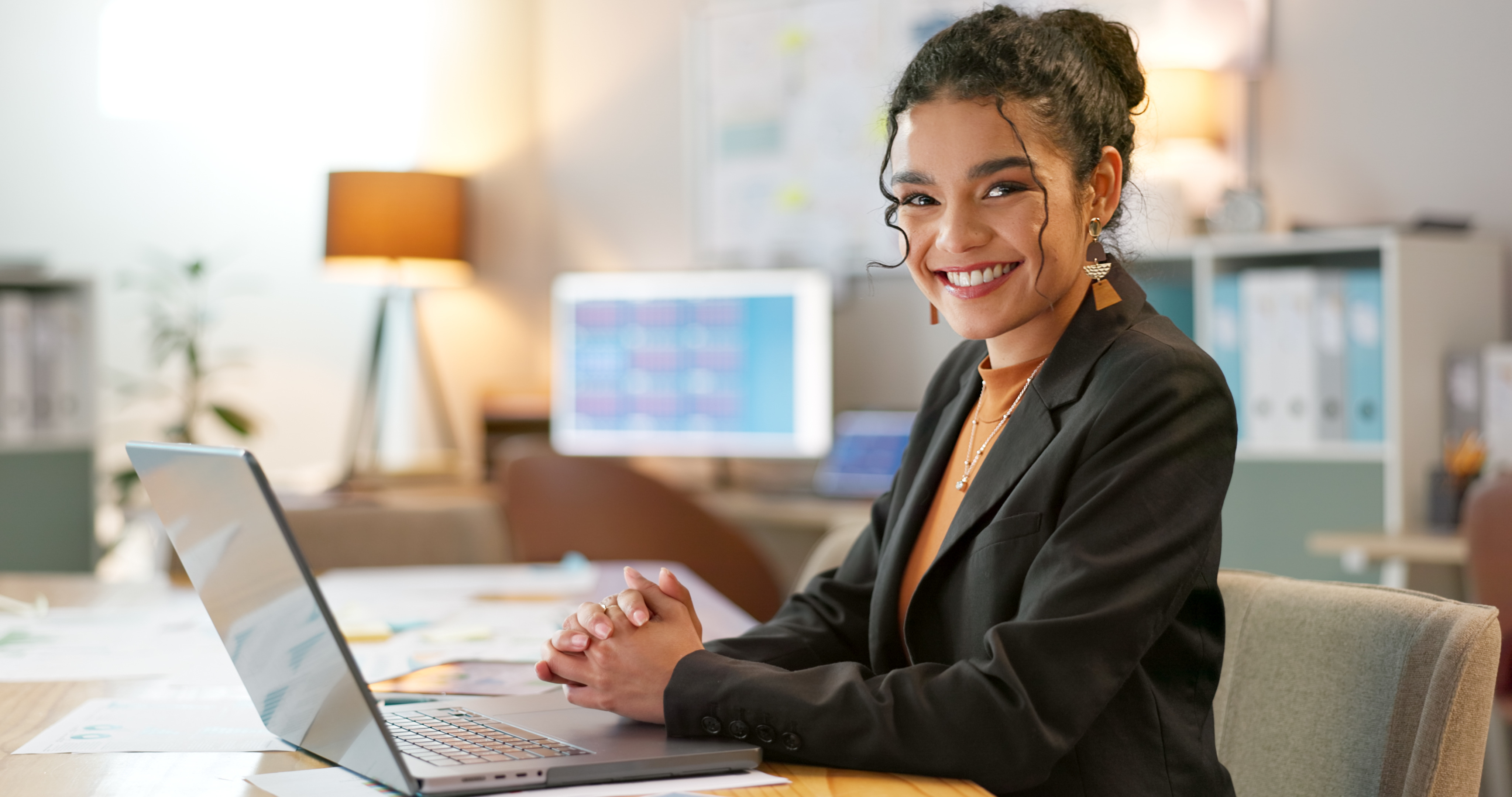 A professional woman smiling on computer