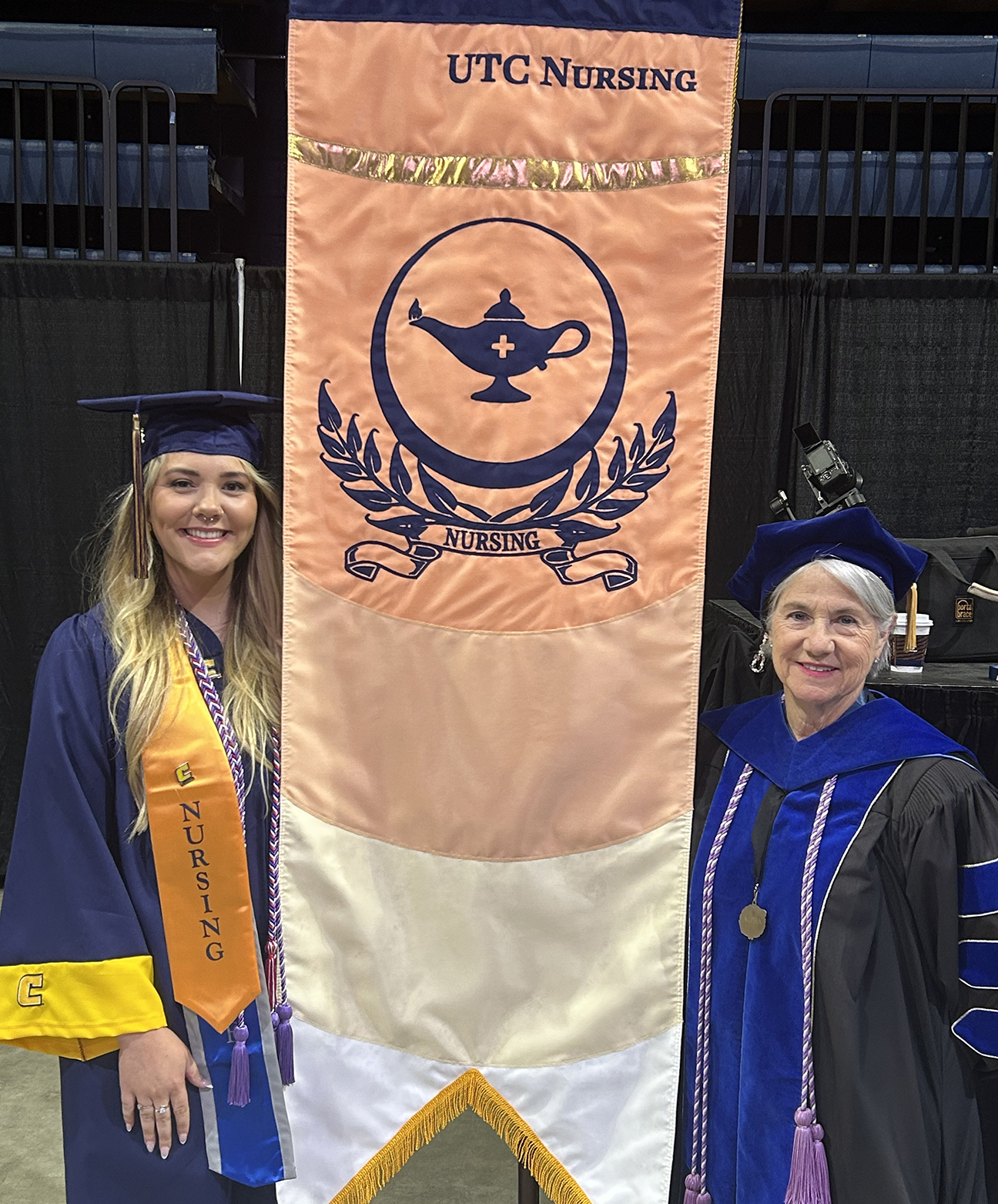 Makayla Bernardy and Chris Smith carry the new gonfalon for the College of Nursing.
