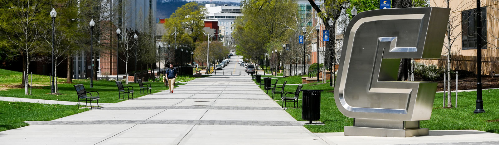 Sidewalk on campus with Silver Power C sign