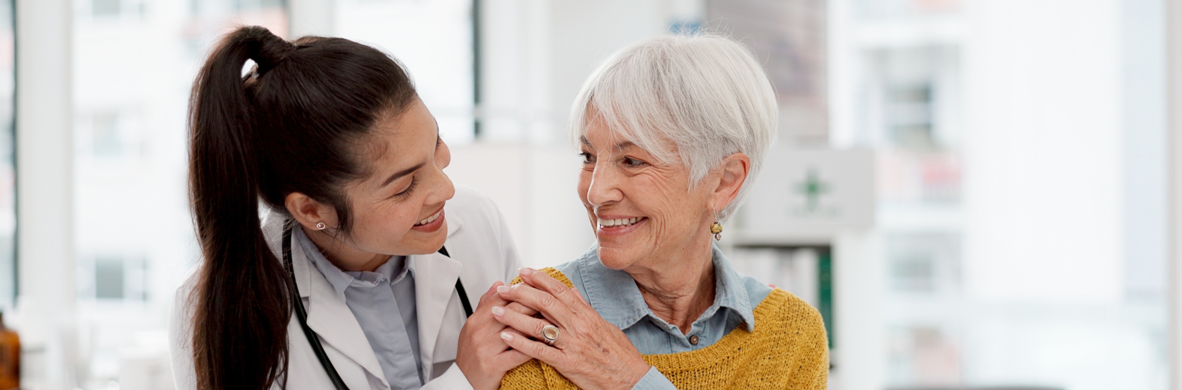 A smiling CNA takes care of her happy elderly patient