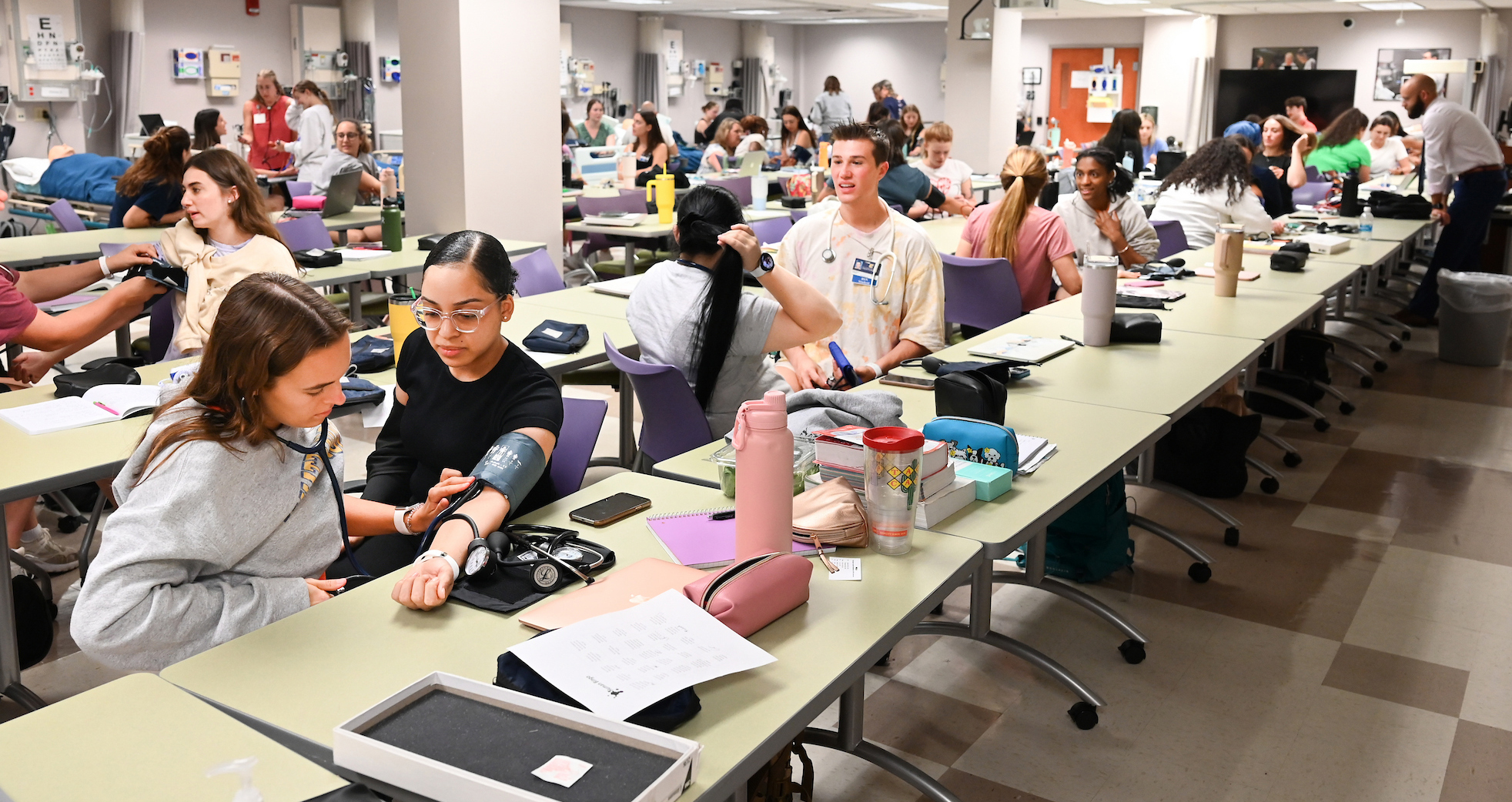 Accelerated BSN students practice taking blood pressure on the first day of class