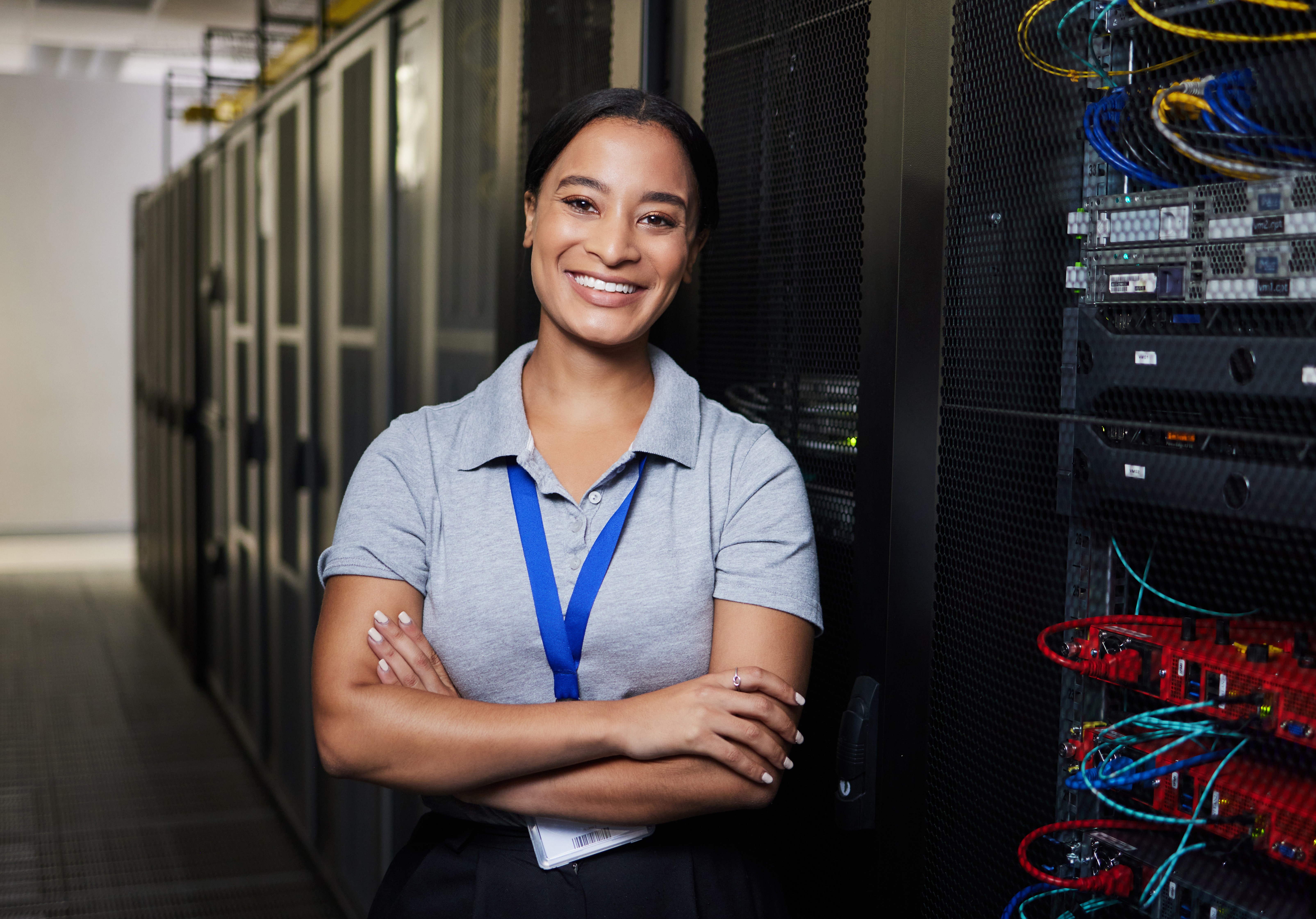 A female IT professional smiles at her cybersecurity job.