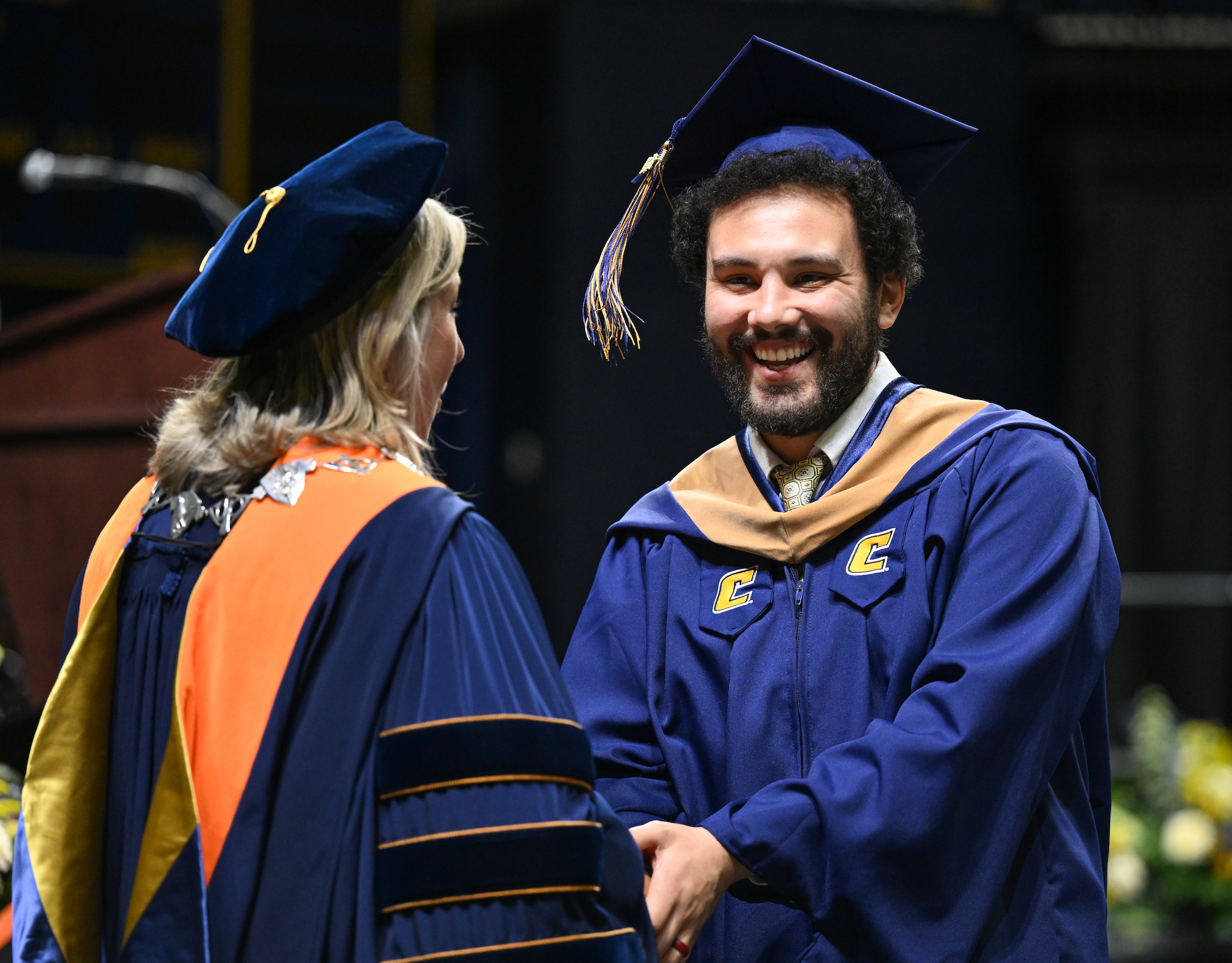 Man shakes hands with the Chancellor as he receives his graduate degree at UTC commencement.