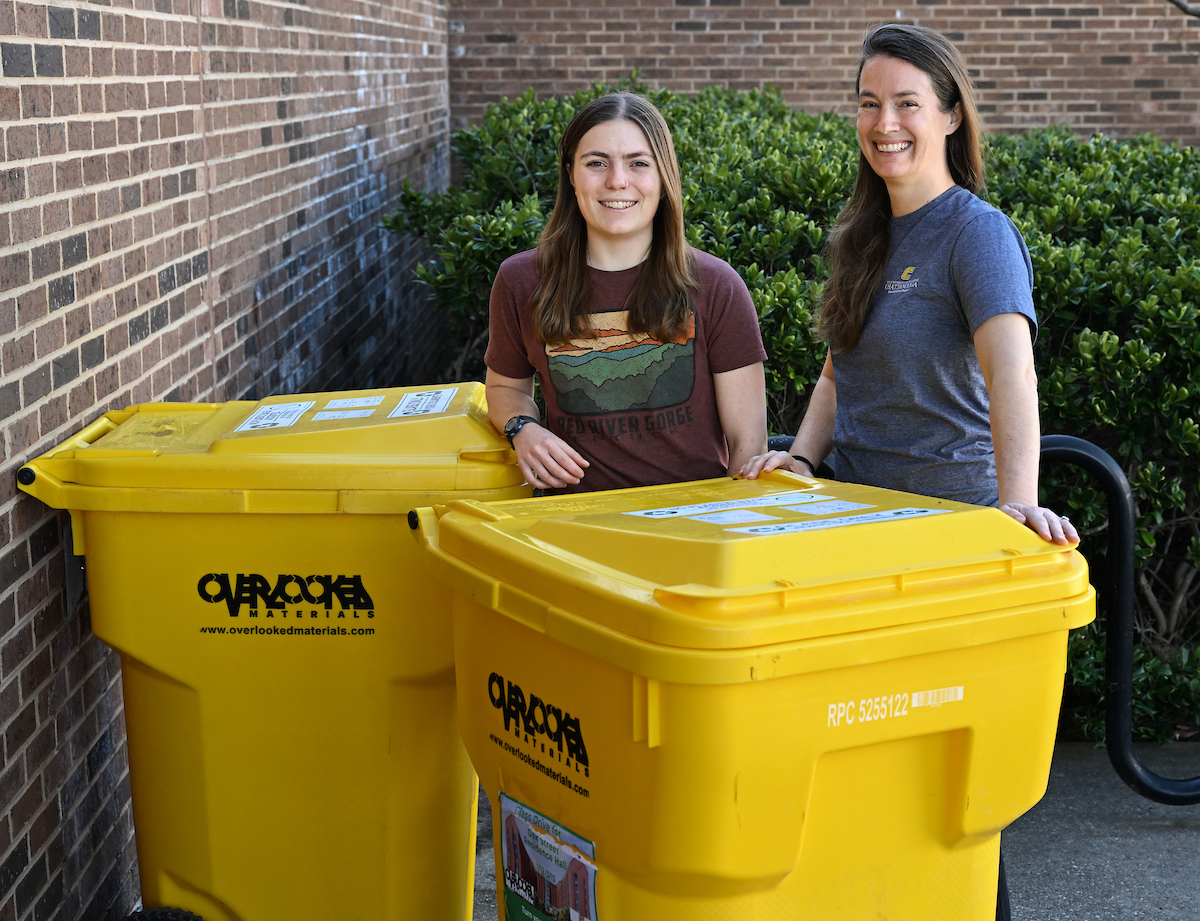 Environmental Studies student and faculty member by Overlooked Materials glass collection bins