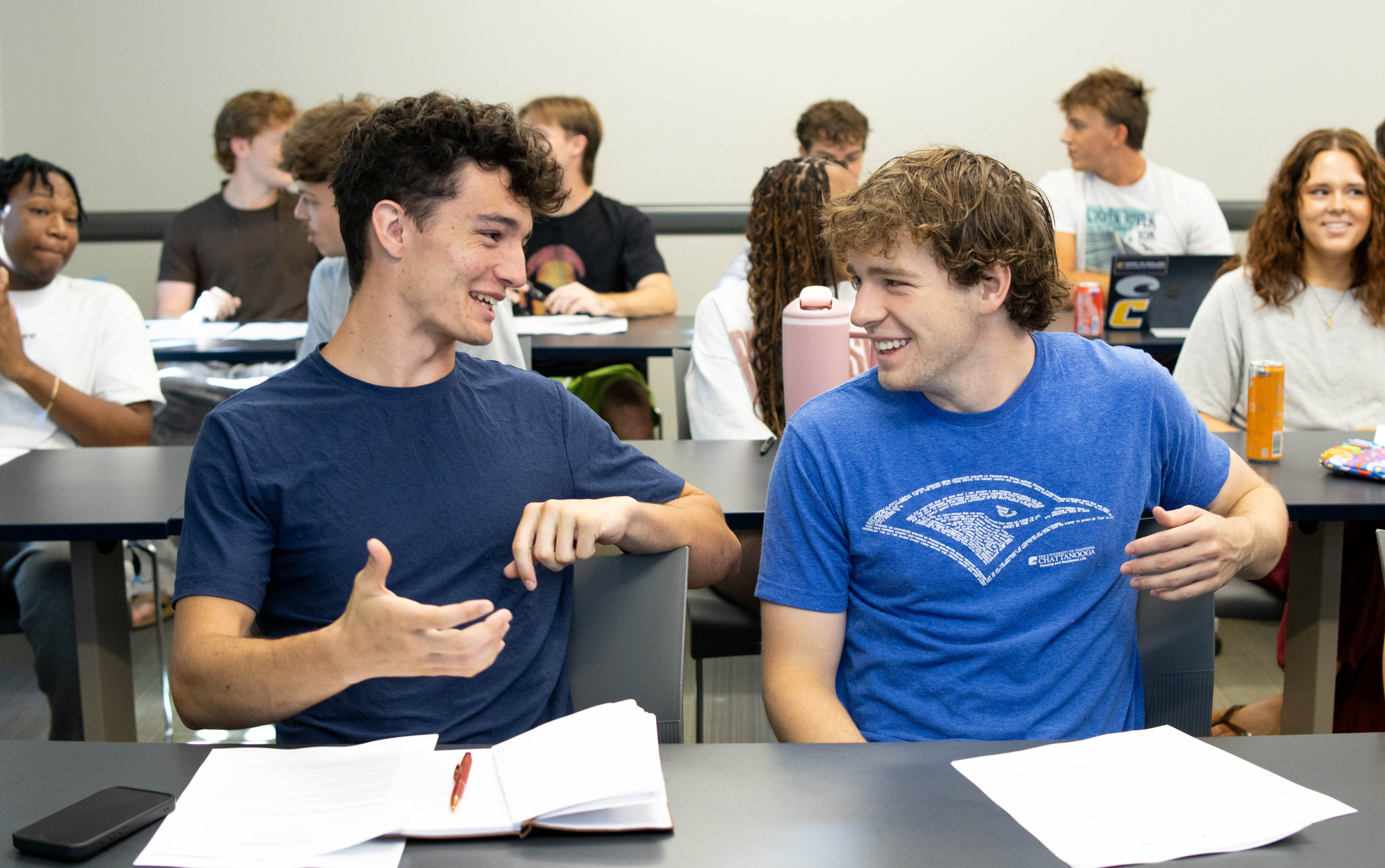 Two male students discuss the assignment in an RCOB classroom.