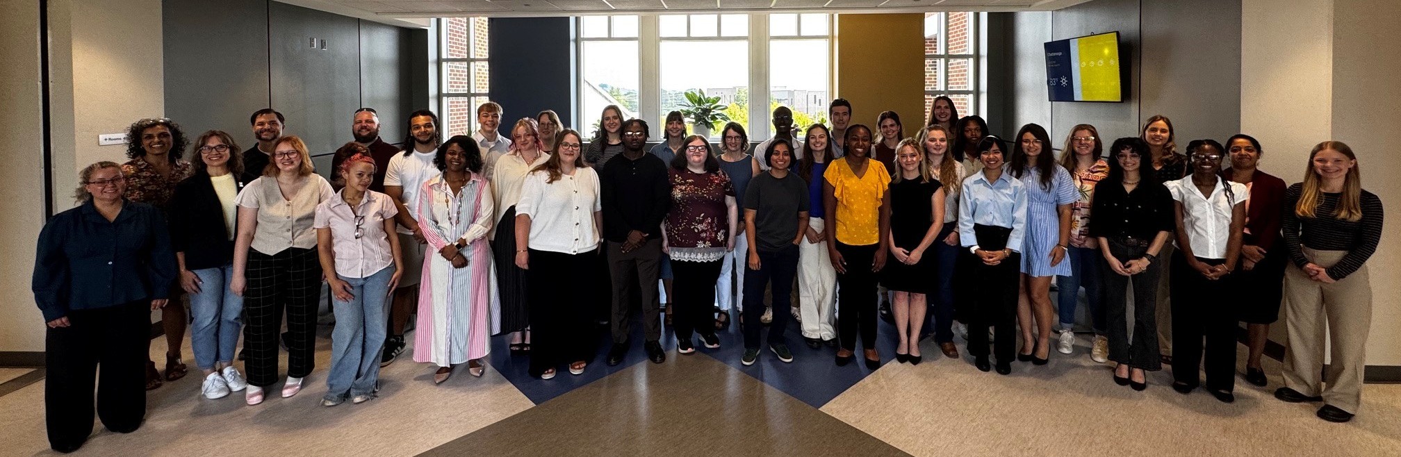 A large group of people standing together indoors for a photo.