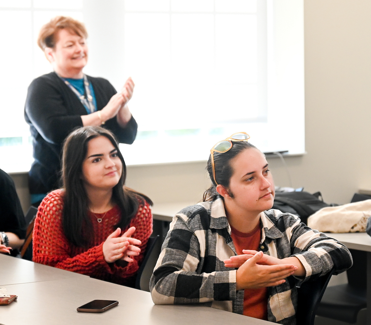 Two UTC social work students clapping in class