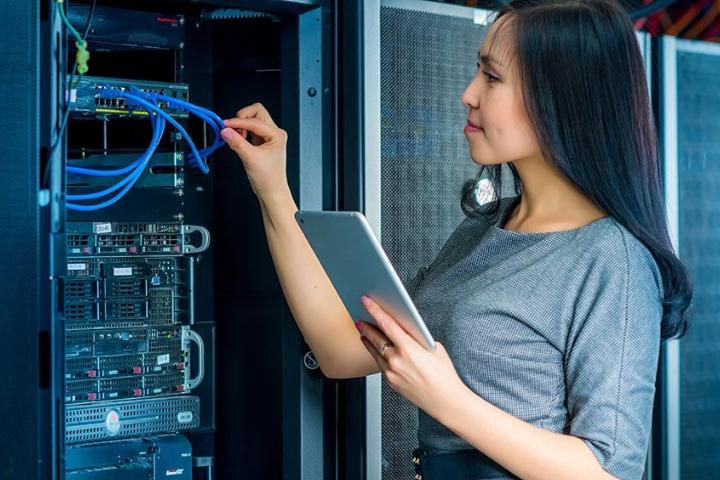 A female network engineer working on a router system.