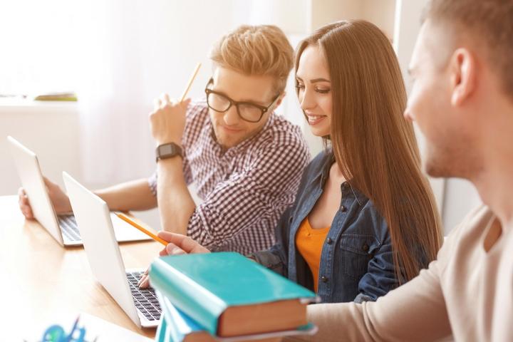 three people looking at their computers