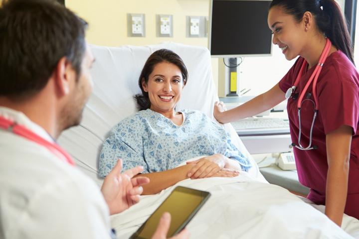 A nurse and doctor talking with a patient