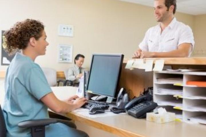 Two people in scrubs discussing over a desk