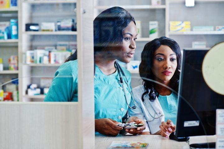 Two female pharmacy technicians behind counter