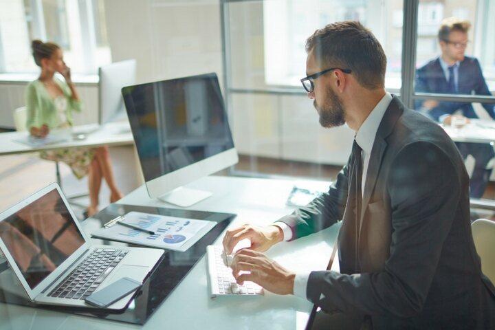 Man in the office looking at his laptop