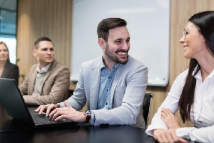 Man smiling at woman with laptop