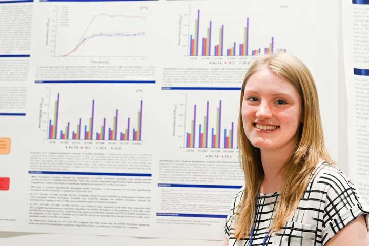 Student in front of research poster presentation