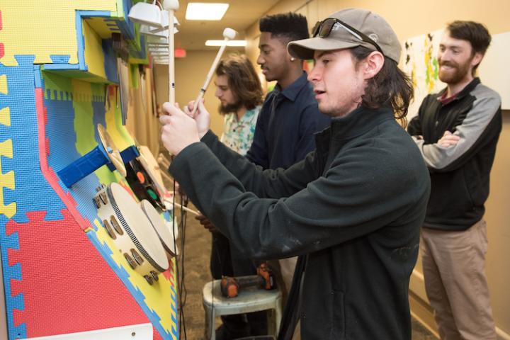 Students interacting with colorful music wall 