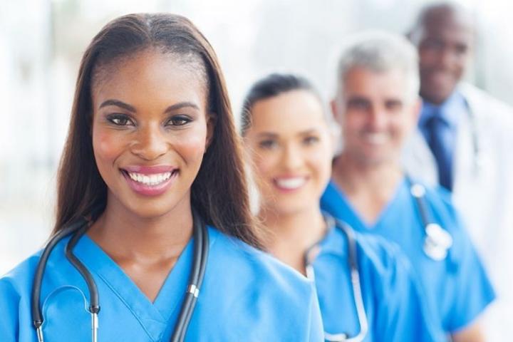 A group of nurses and doctors standing together and smiling