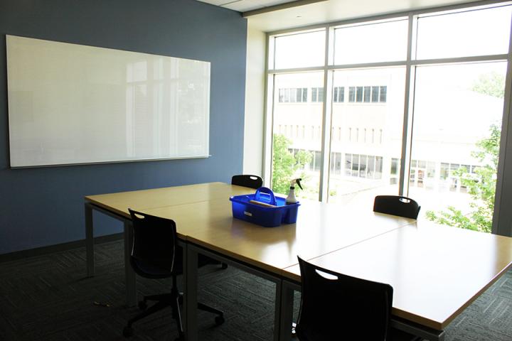 medium study room with four chairs and cleaning supplies
