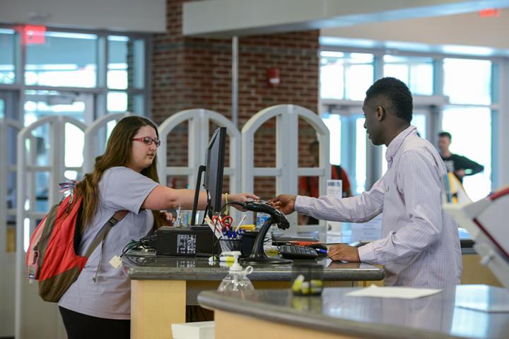 students at check out desk