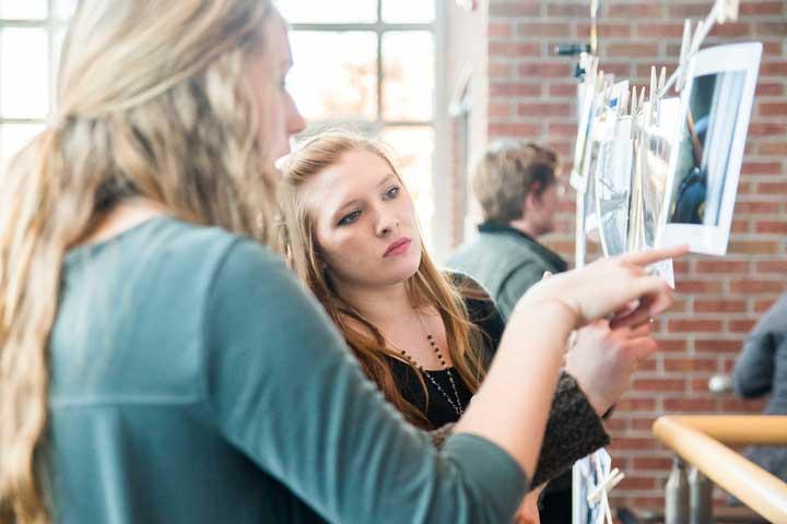 Student shows her work to a fellow student