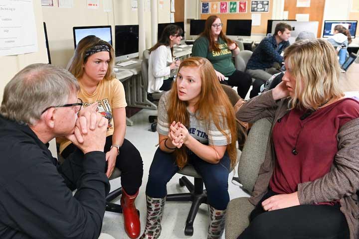 Students sit in a group discussion