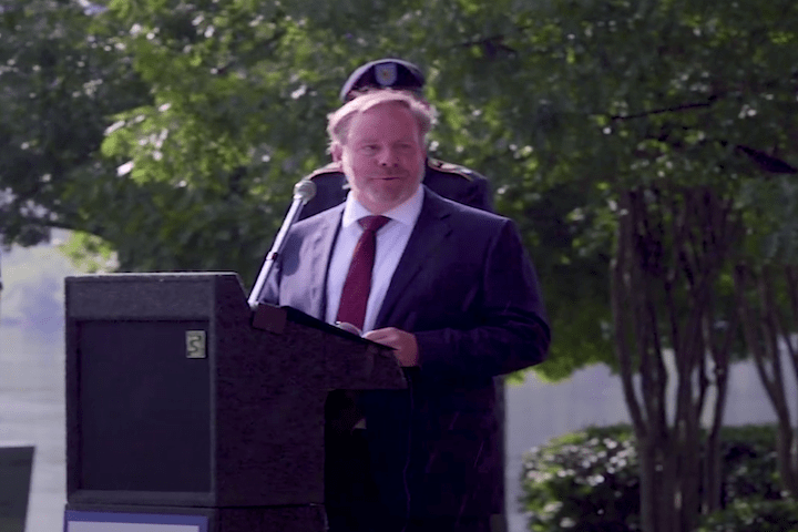 man standing at podium giving speech