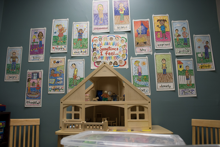 Counseling Center Room 3 doll house in playroom with positive images on wall behind it