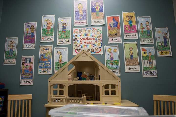 doll house in playroom with positive images on wall behind it