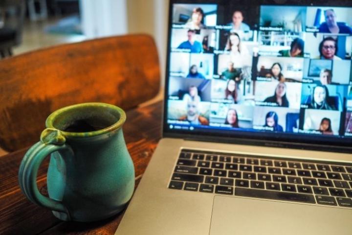 A laptop with Zoom opened and several participants on the call. 