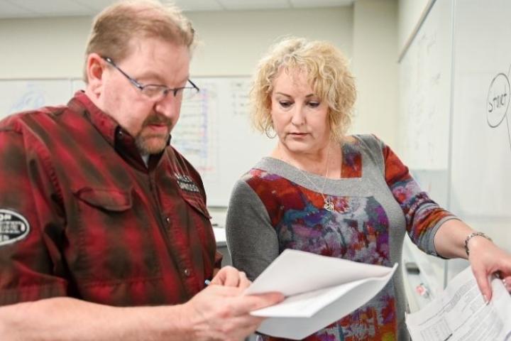 Kimberly Casperson, PMP Instructor, helping a student work a problem at a whiteboard
