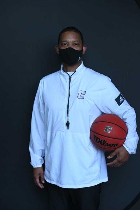 Lamont Paris is not THAT Moc Coach Lamont Paris poses for photo holding basketball and wearing a mask
