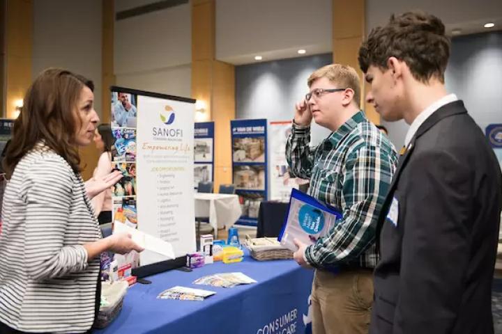 Students speaking with an employer at a career fair