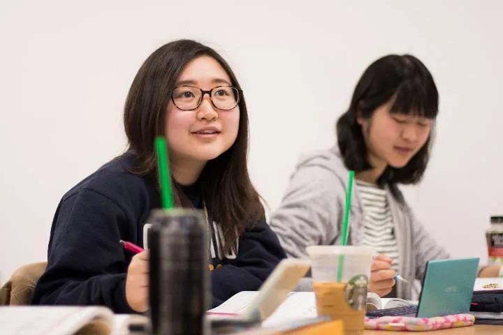 two students taking notes