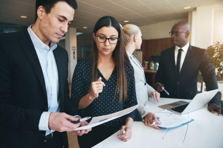 A group of business people talking with one another.