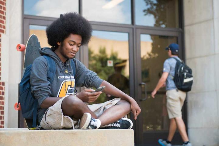 Smiling student on his phone