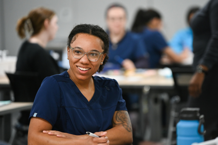 woman smiling while taking class notes