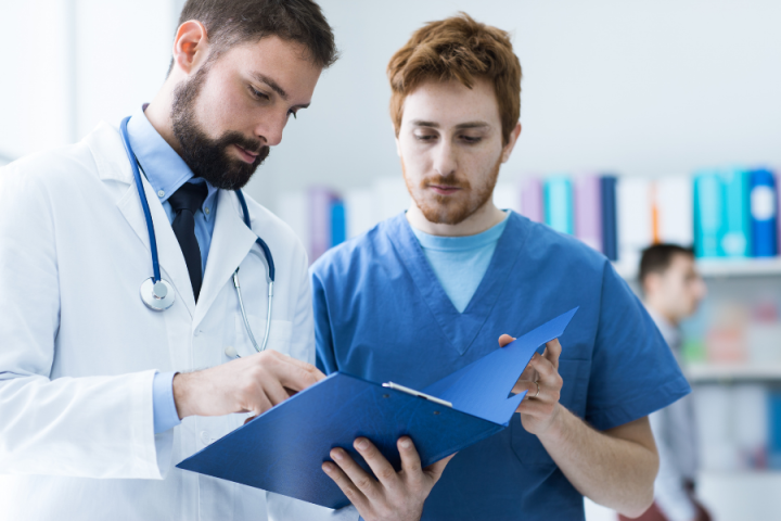 Male edical assistant speaking to doctor