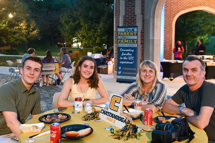 FFW Family Photo A family attending Fall Family Weekend poses for a photo during dinner.