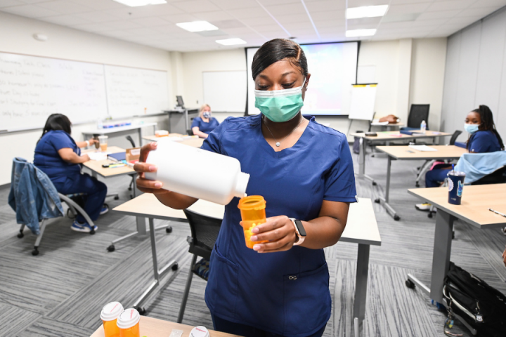 pharmacy tech female student filling pills