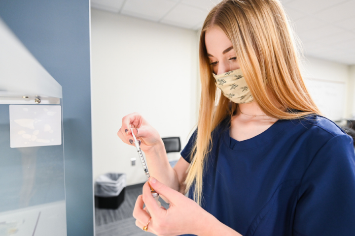 pharmacy tech female student filling a vial