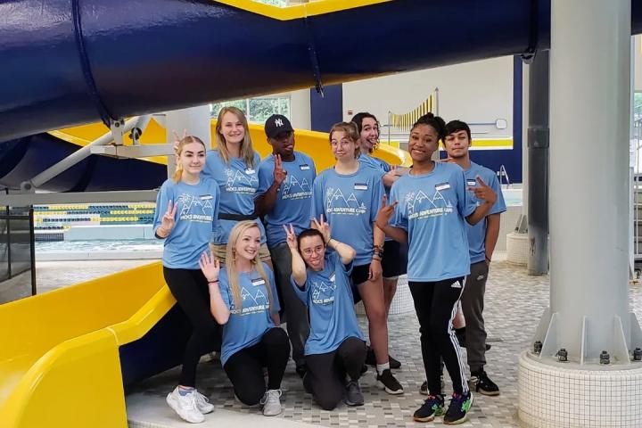 Mocs Adventure Camp Counselors make silly poses in front of the water slide.