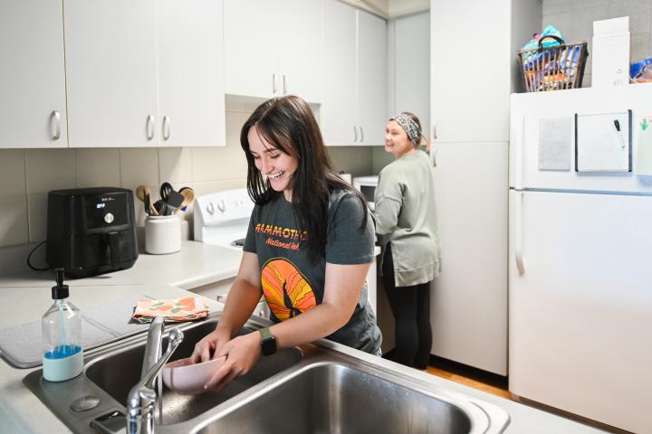 two roommates in kitchen, washing dishes