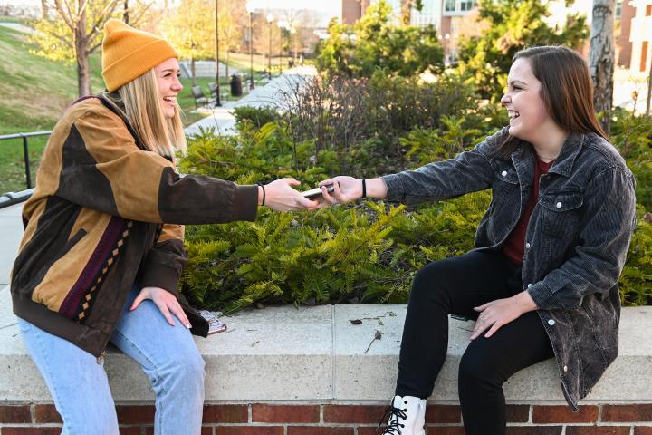 students passing their smartphone