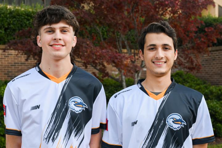 Two of the UTC Rocket League A team players pose in their jerseys.