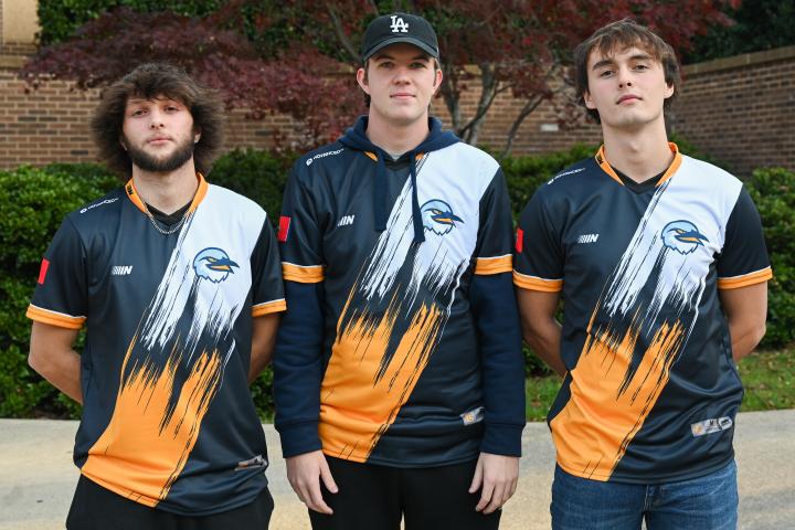 Three of the UTC Valorant team players pose in their jerseys.