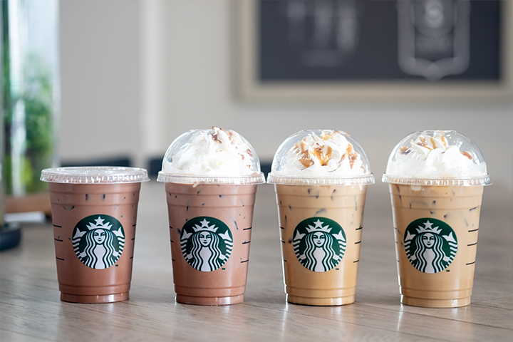 A variety of Starbucks beverages on counter.