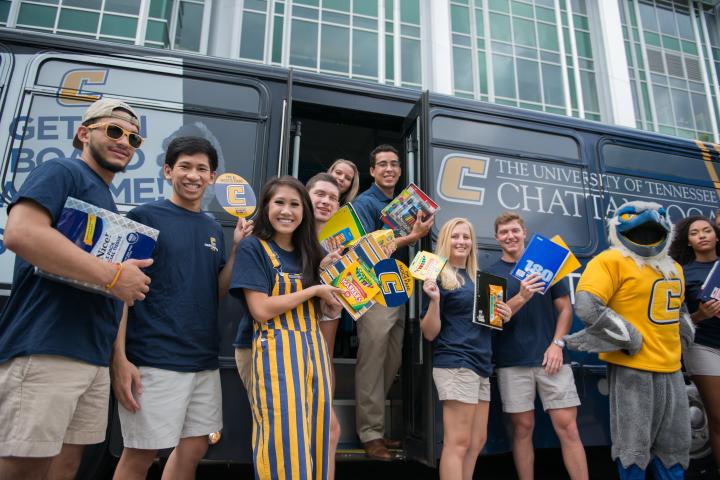 Students standing in and around UTC bus