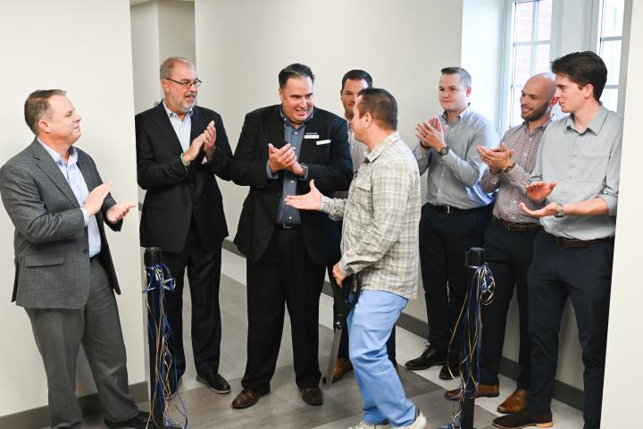 UTC Rollins College of Business Sales Center Ribbon Cutting Eight people shaking hands after a ribbon cutting ceremony.